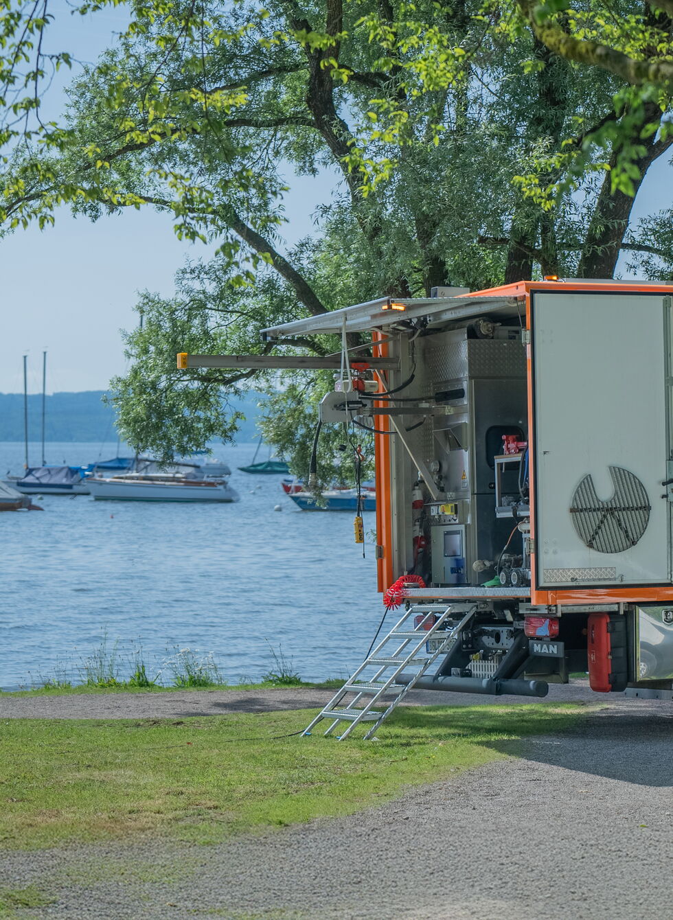 Oranger Sanierungsanhänger von Swietelsky-Faber beim Projekt am Ammersee